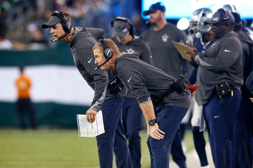 Dallas Cowboys head coach Jason Garrett (foreground) ands coaching staff watch their players...