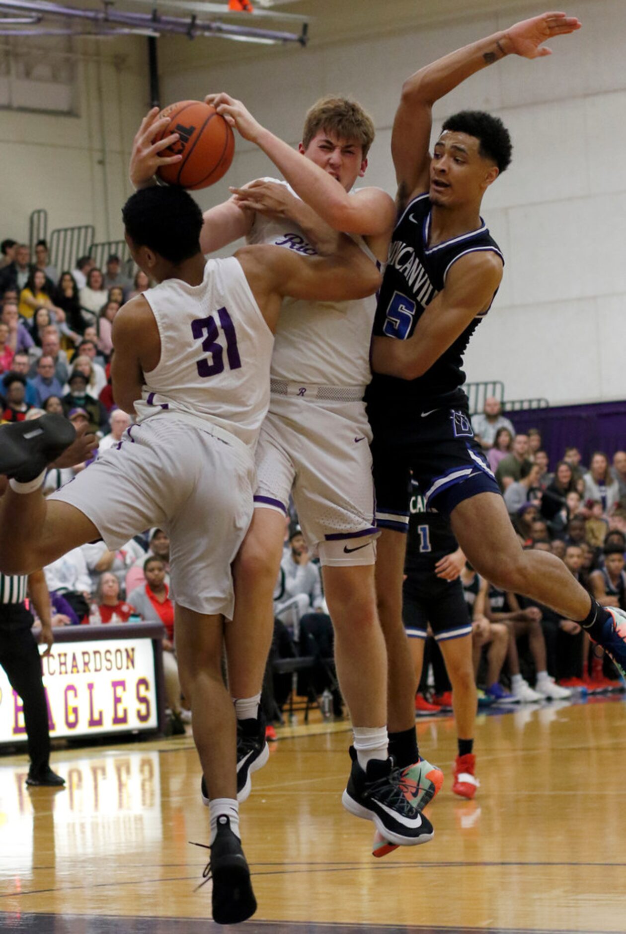 Richardson's Gannon Parker (41), center, battles for a rebound with teammate Derek Burns...