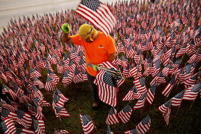 José Durán coloca banderas estadounidenses para conmemorar Memorial Day en la esquina...