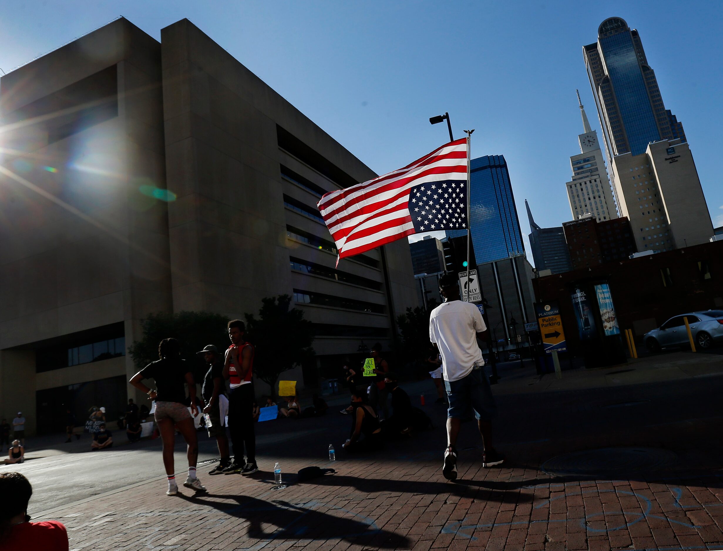 A protestor carries an upside down U.S. flag as others circled and stopped traffic on Ervay...