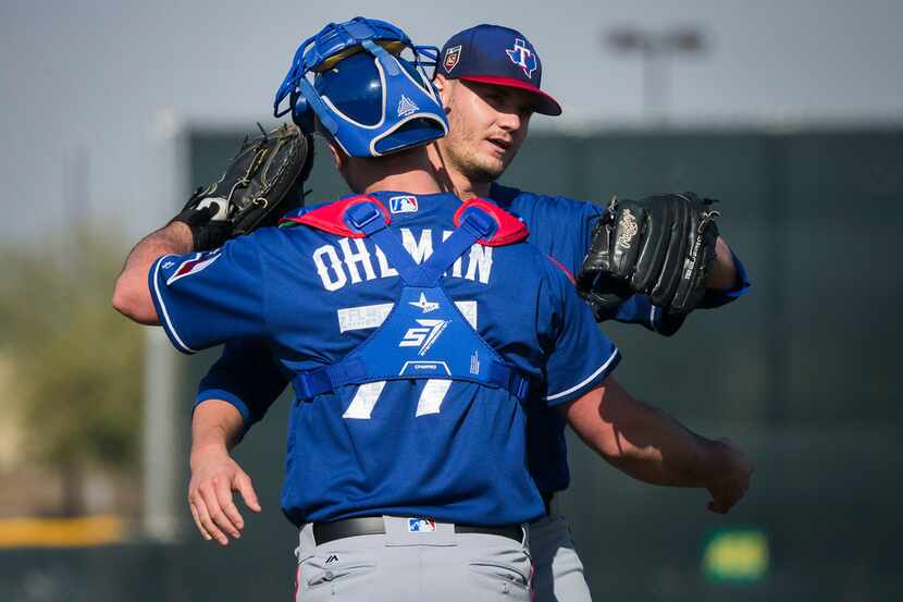 Texas Rangers pitcher Connor Sadzeck (59) hugs catcher Mike Ohlman (77) after pitching...