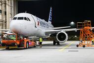 An American Airlines plane is towed into a maintenance hangar for service, Thursday, Aug....