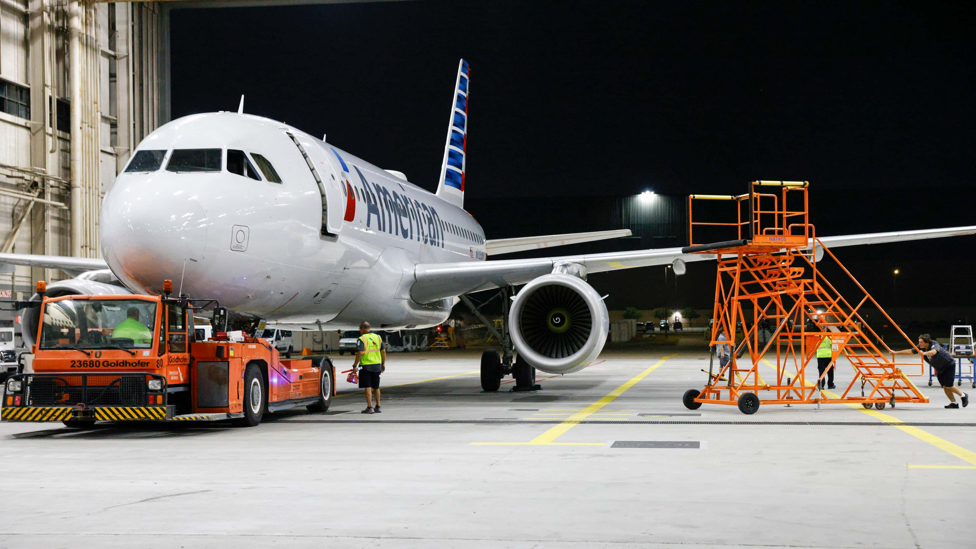 An American Airlines plane is towed into a maintenance hangar for service, Thursday, Aug....