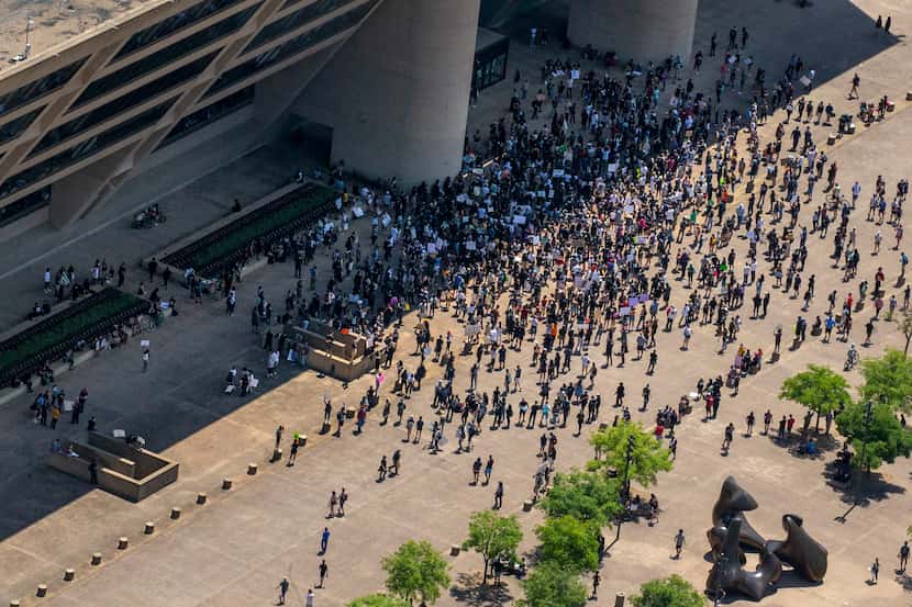 After marching throughout downtown Dallas, protesters march back to Dallas City Hall during...