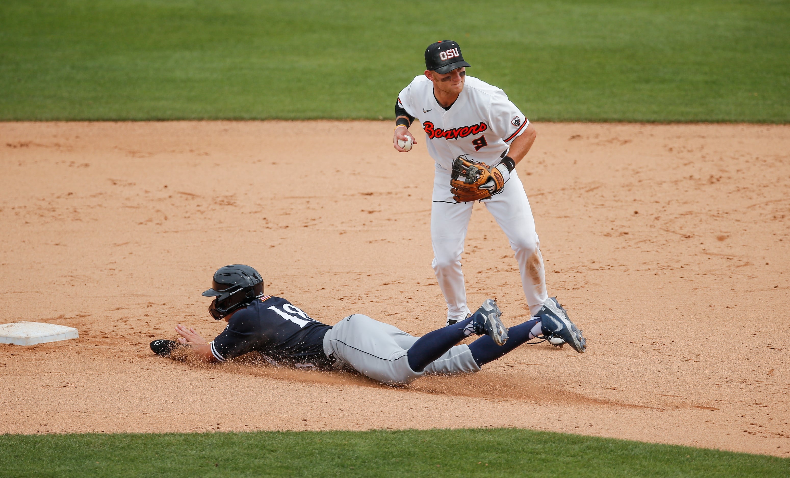 Oregon St. infielder Andy Armstrong (9) throws to first for a double play after forcing out...