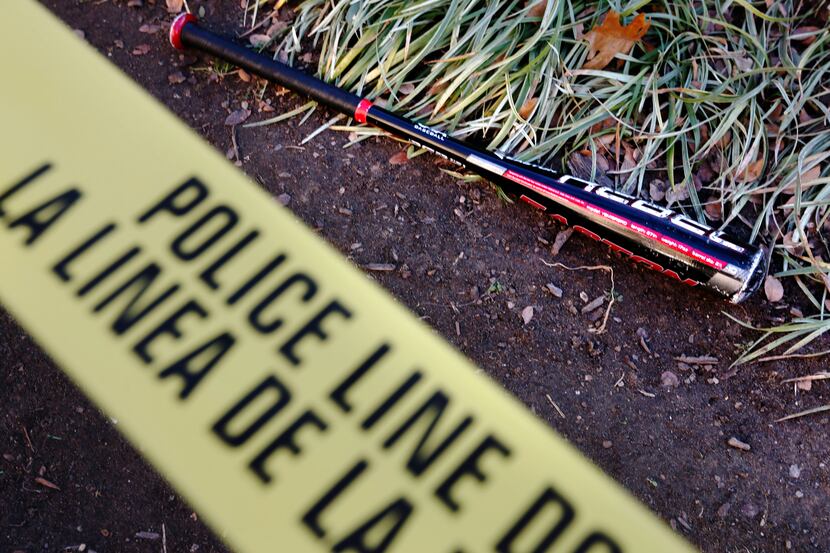 A baseball bat lies inside of scene tape roping off the scene of what witnesses say was a...
