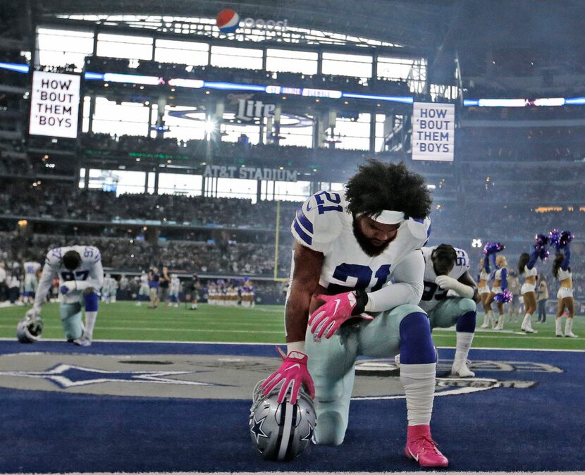 Dallas Cowboys running back Ezekiel Elliott (21) prays in the end zone before the...