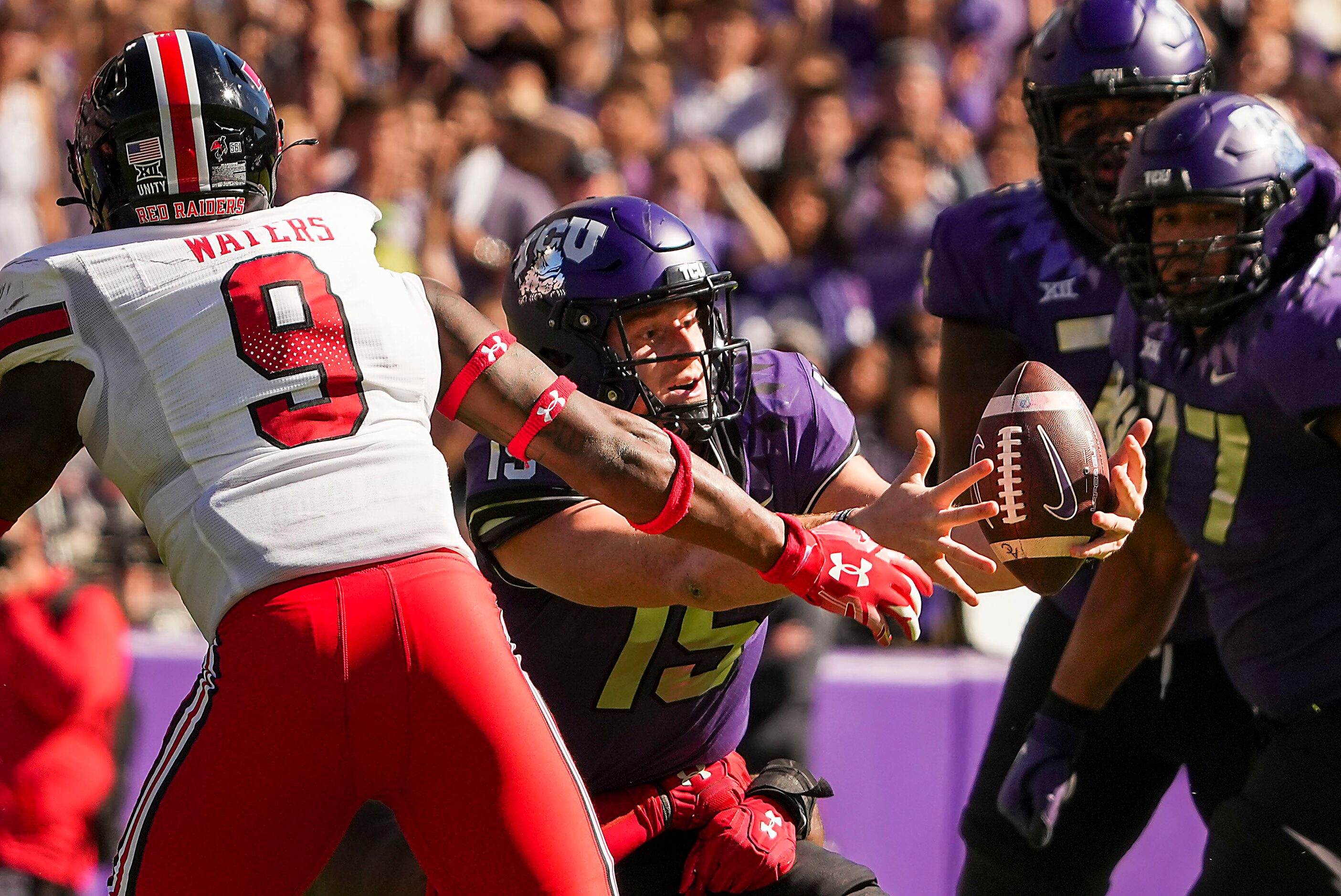 TCU quarterback Max Duggan (15) grabs his own bobble as he is brought down for a loss during...