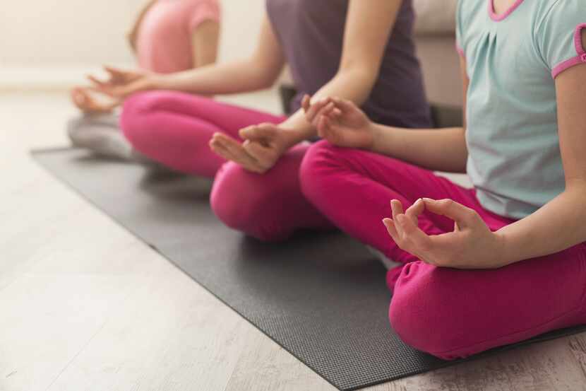 Un grupo de personas practican yoga.