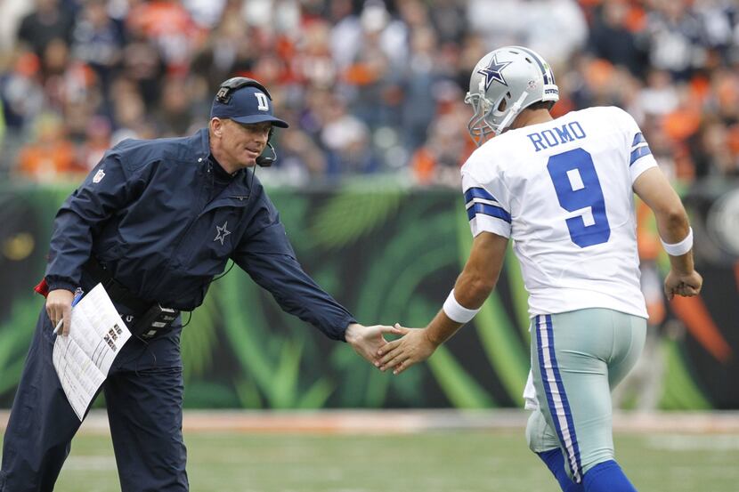 Dallas Cowboys head coach Jason Garrett congratulates quarterback Tony Romo (9) after...