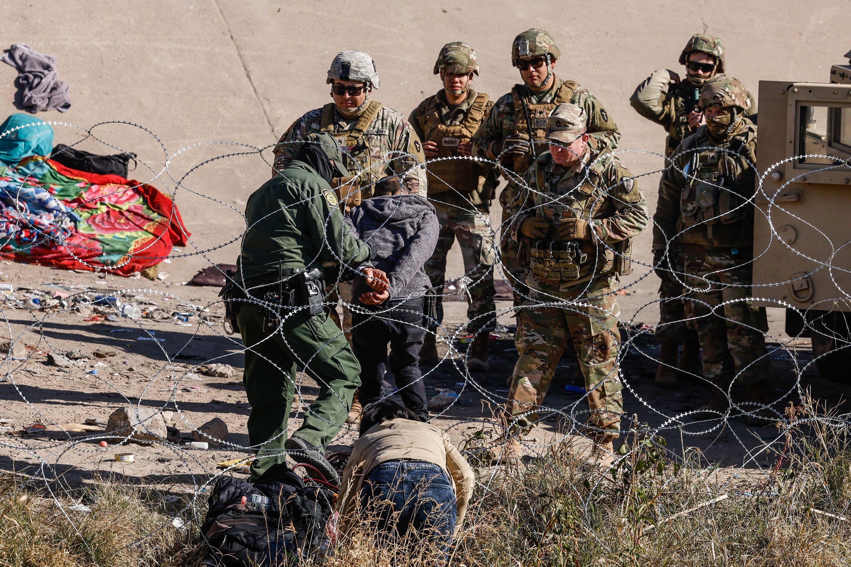 A group of migrants defy the orders of the Texas National Guard not to cross the Rio Grande...