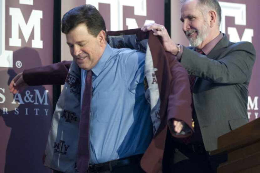 Texas A&M Univerity President Michael Young puts the maroon blazer on new Athletic Director...