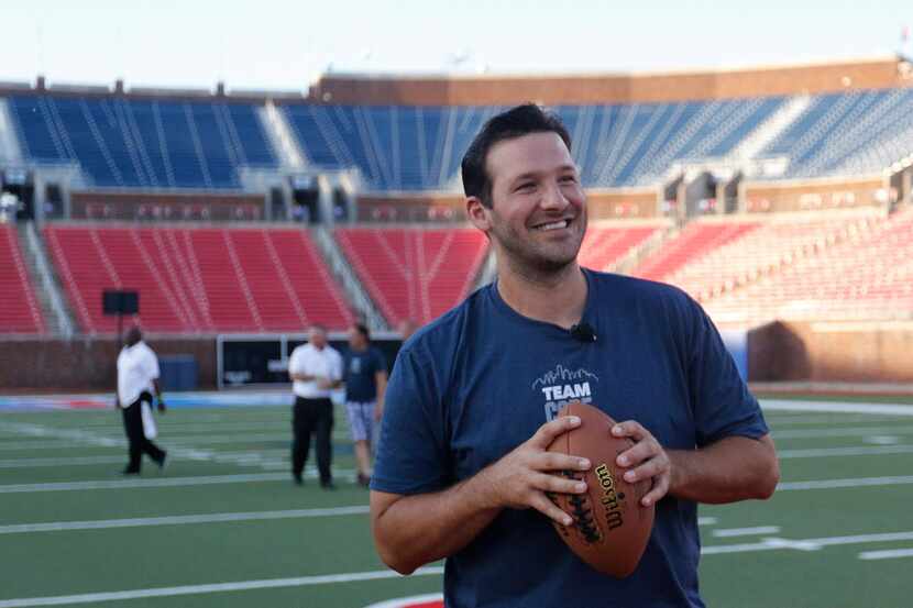 Dallas Cowboys quarterback Tony Romo prepares to throw a pass to fans while they played...