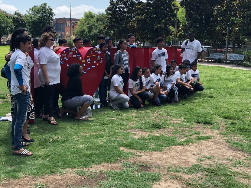 Los participantes en el Mes de la Herencia Inmigrante posaron con sus camisetas luego del...