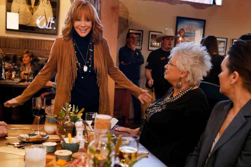 Country music legend Reba McEntire visits with friends during the opening of her new...