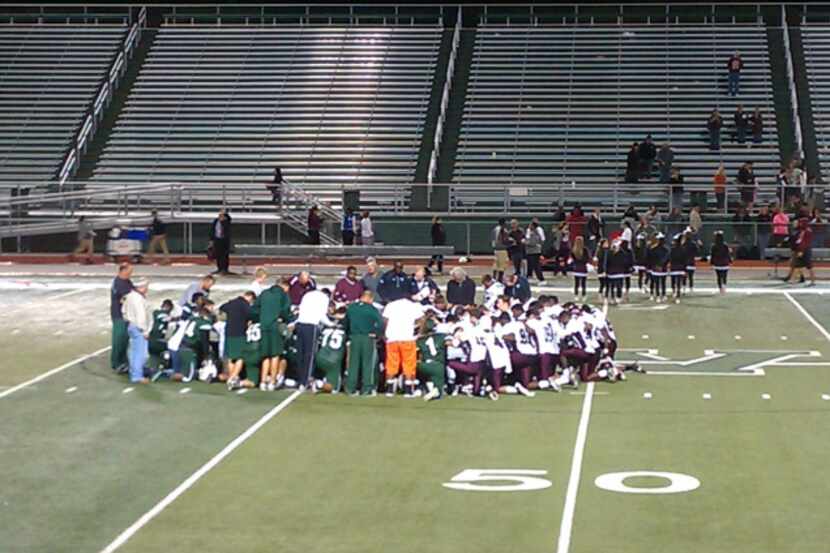 Players from the Waxahachie and Ennis JV teams gathered in prayer after Triston Simpler was...