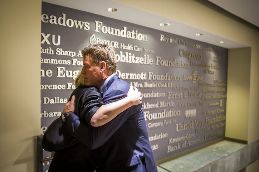 Troy Aikman hugs Jennifer Sampson, CEO of United Way, after an interview  about why he...