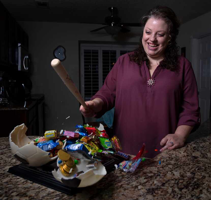 Jill Baethge, owner of Kaboom Chocolaka, smashes a soccer ball made of white chocolate as...