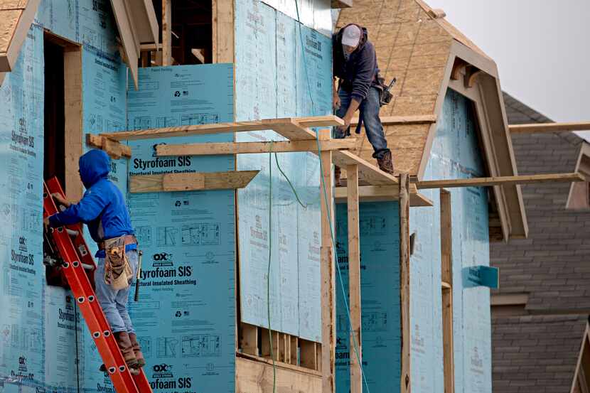 Workers build a house in the Richwoods: Landon Homes subdivision  in Frisco. A shortage of...