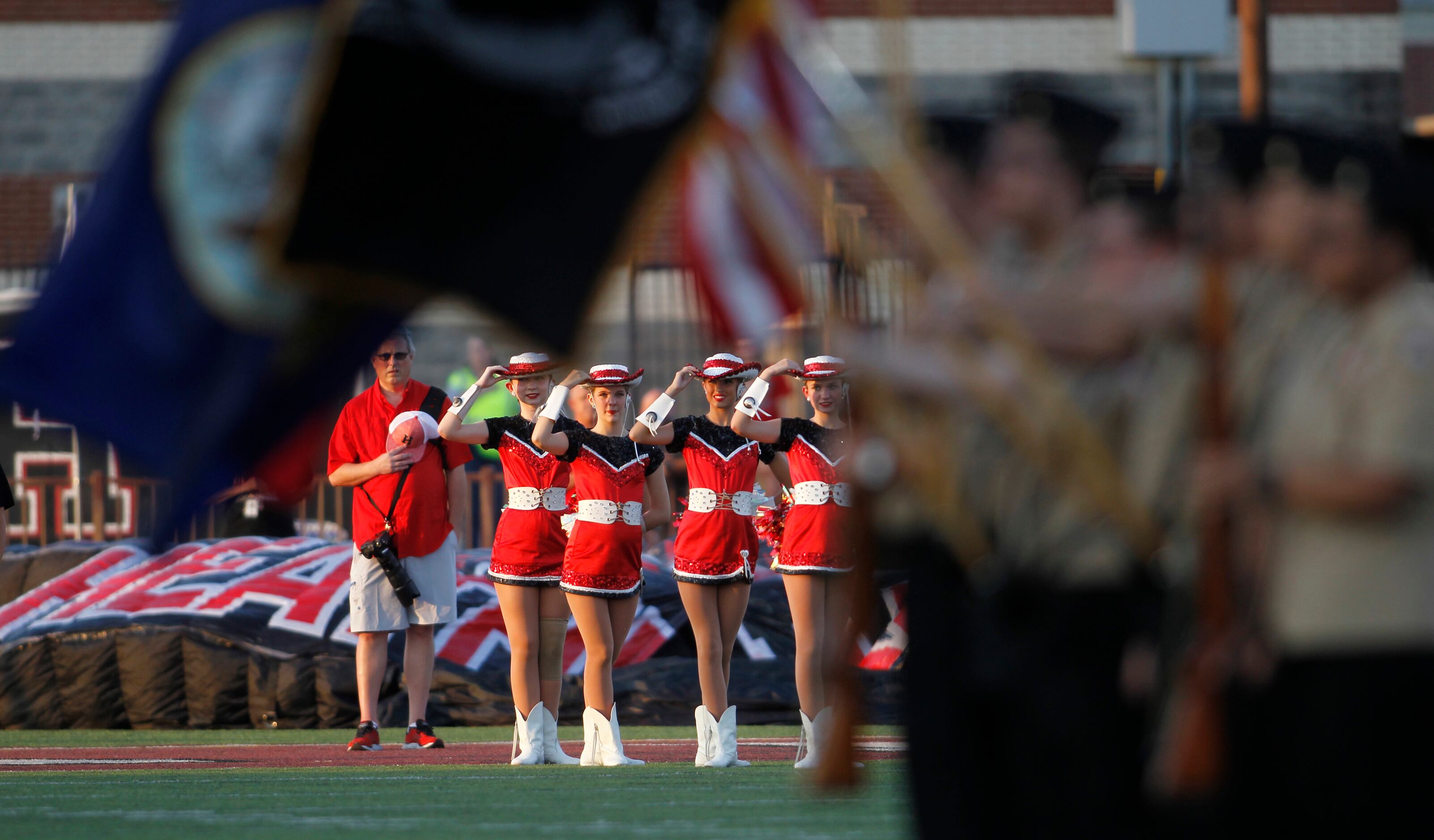 Rockwall Heath drill team members salute during a moment of silence as part of a tribute to...