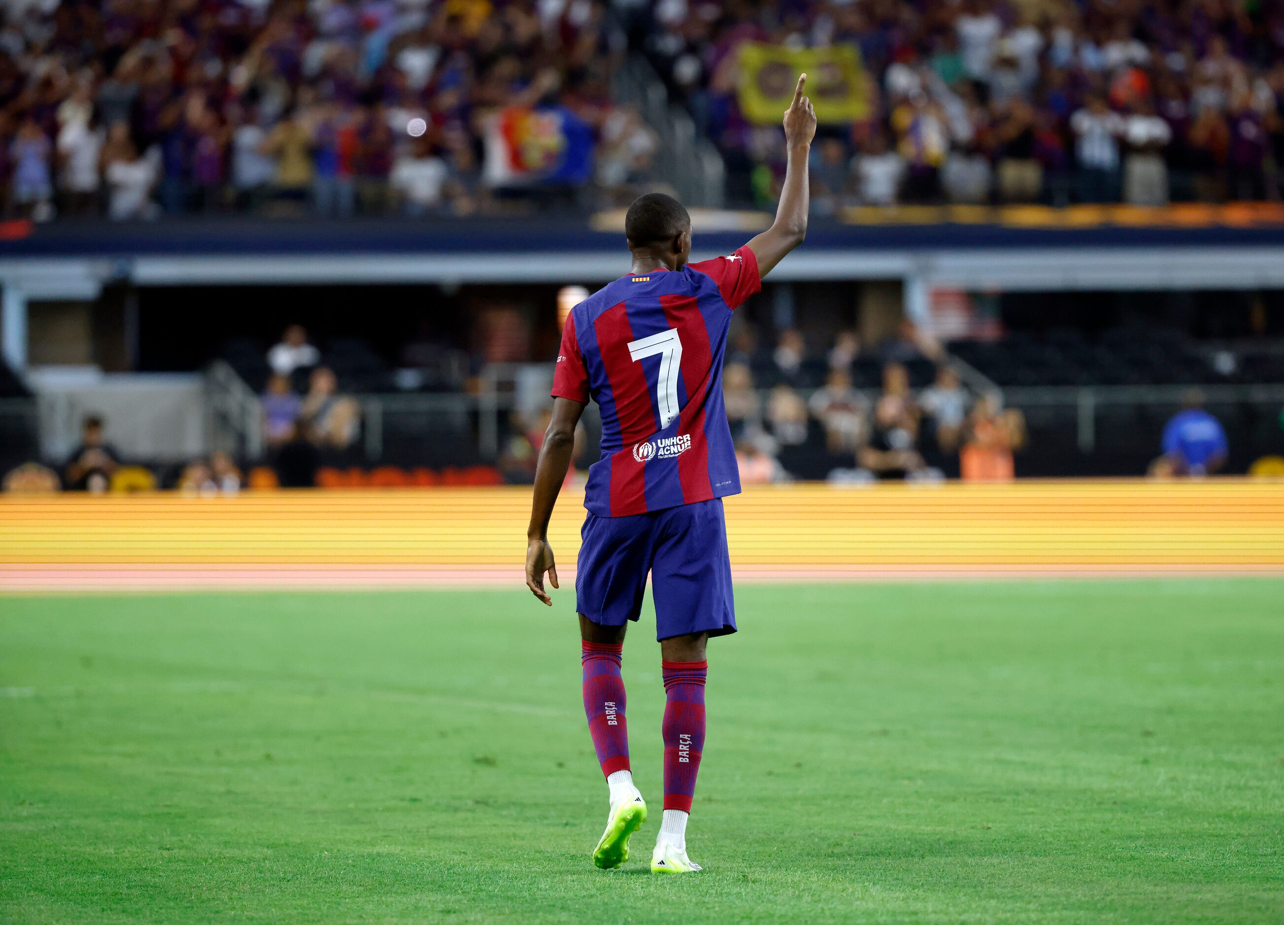 Barcelona forward Ousmane Dembélé (7) raises his finger after scoring a first half goal...