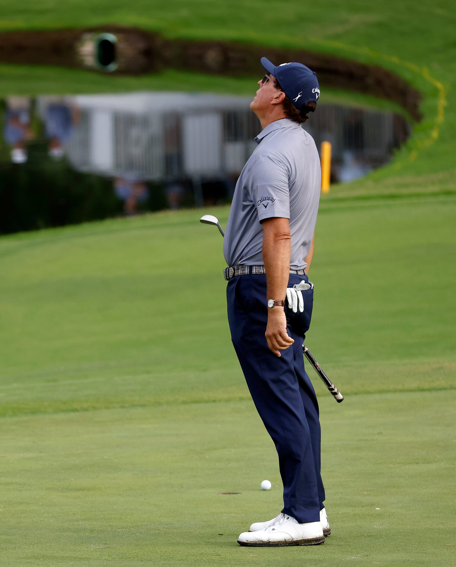 Professional golfer Phil Mickelson reacts after missing his par putt on the par-3, No. 16...