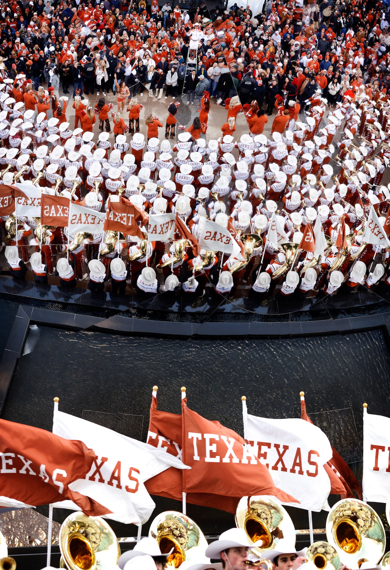 The University of Texas Longhorn Band, reflected in the large Sky Mirror sculpture, performs...