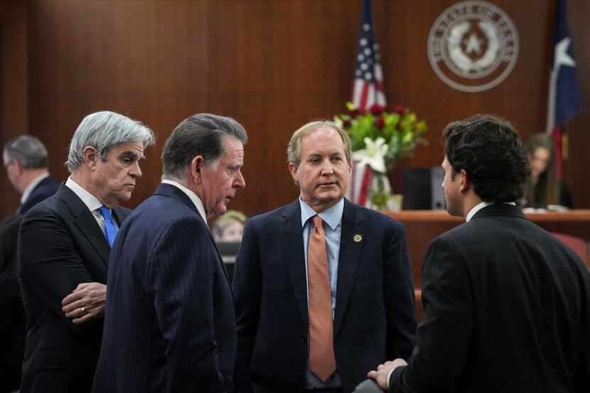 Texas Attorney General Ken Paxton, second from right, talks with his defense attorneys...