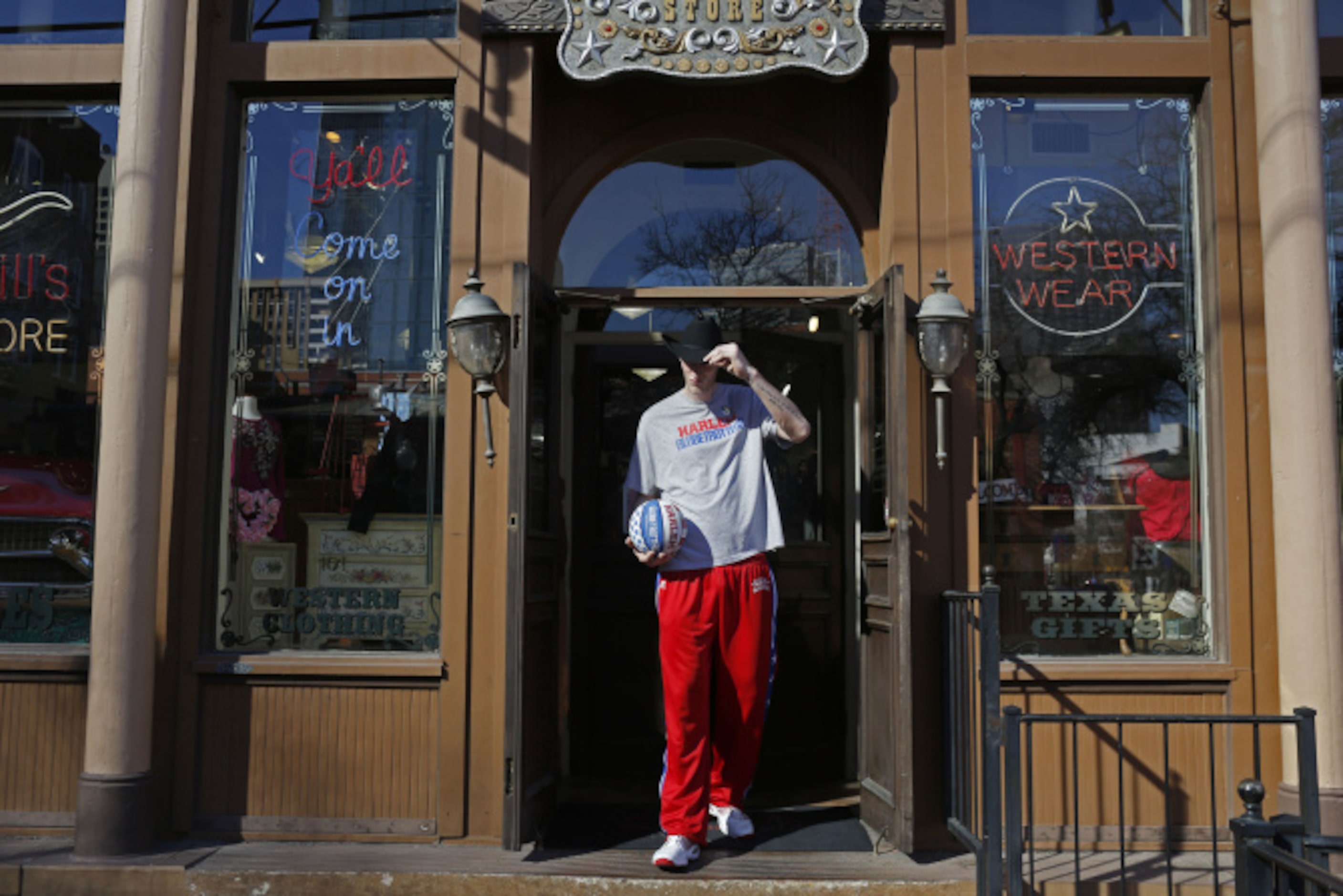 Harlem Globetrotter Paul "Tiny" Sturgess leaves Wild Bill's Western Store with his new hat...