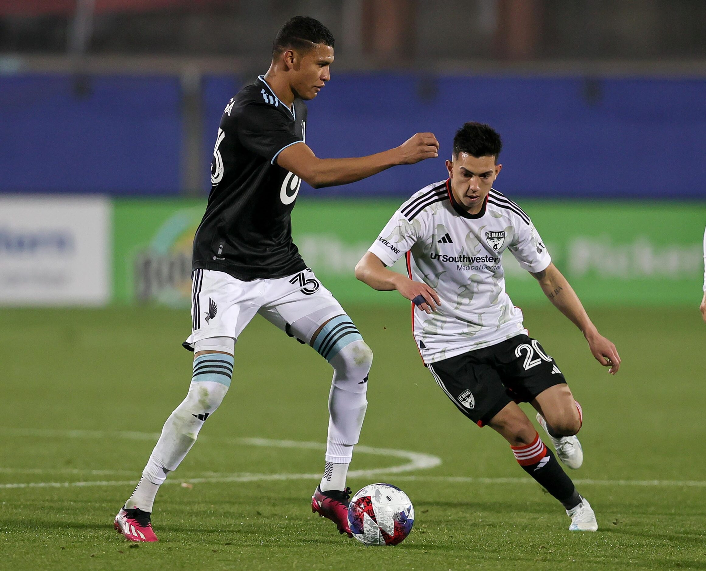 FC Dallas attacker Alan Velasco (20) tries to get around Minnesota United midfielder Kervin...