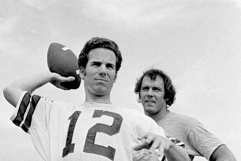 Dallas Cowboys Super Bowl hero Roger Staubach gets set to toss the ball as quarterback Craig...