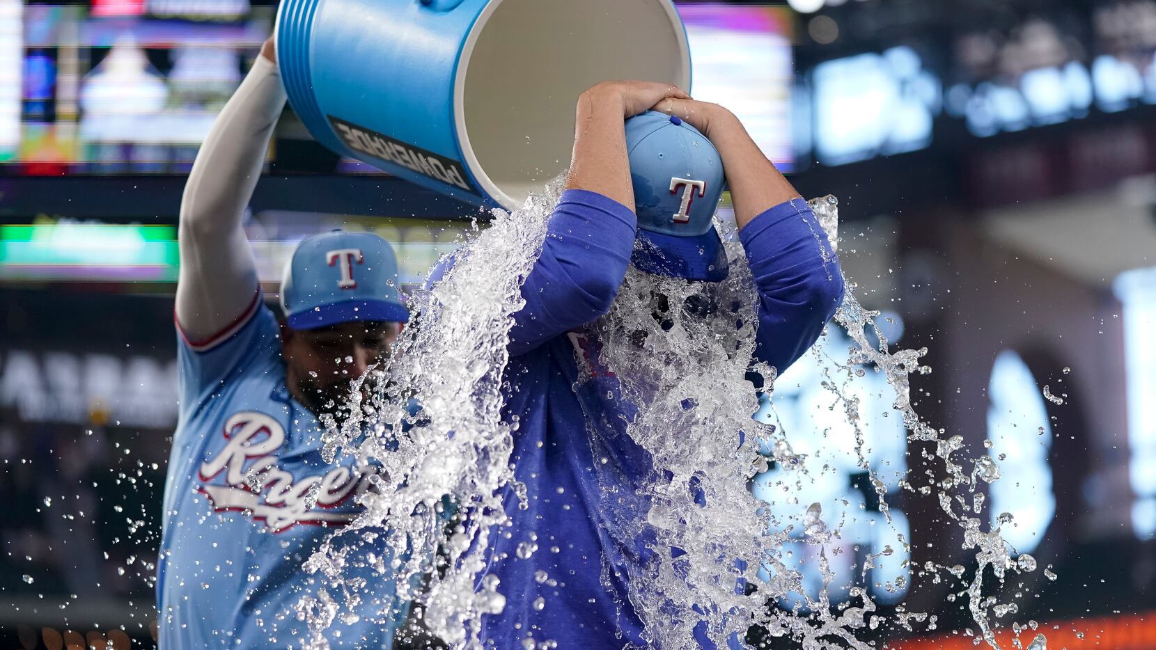 Texas Rangers' Martin Perez, front, is doused with water by Ezequiel Duran, back, after a...