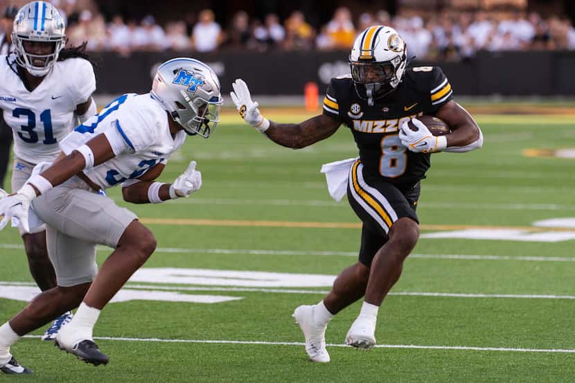 Missouri running back Nathaniel Peat, right, runs past Middle Tennessee safety Jakobe...