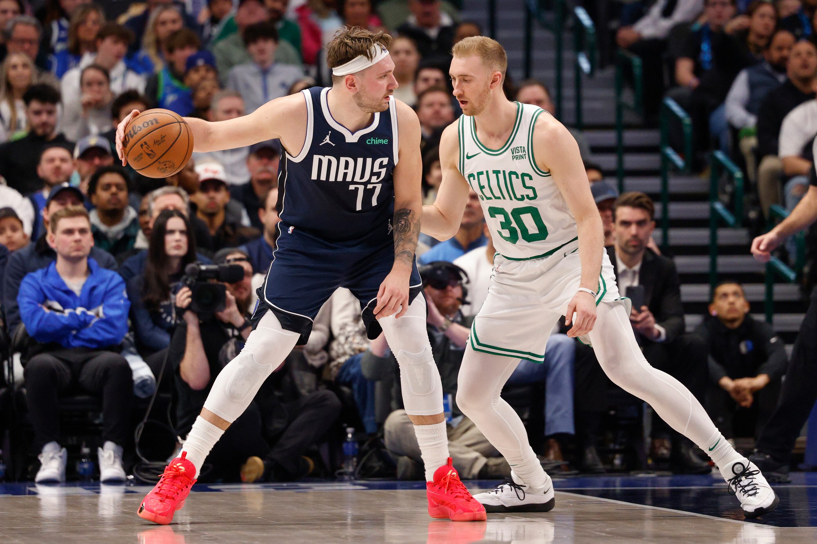 Dallas Mavericks guard Luka Doncic (77) backs down Boston Celtics forward Sam Hauser (30)...