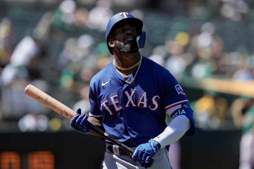 Texas Rangers' Adolis García walks to the dugout after striking out against the Oakland...