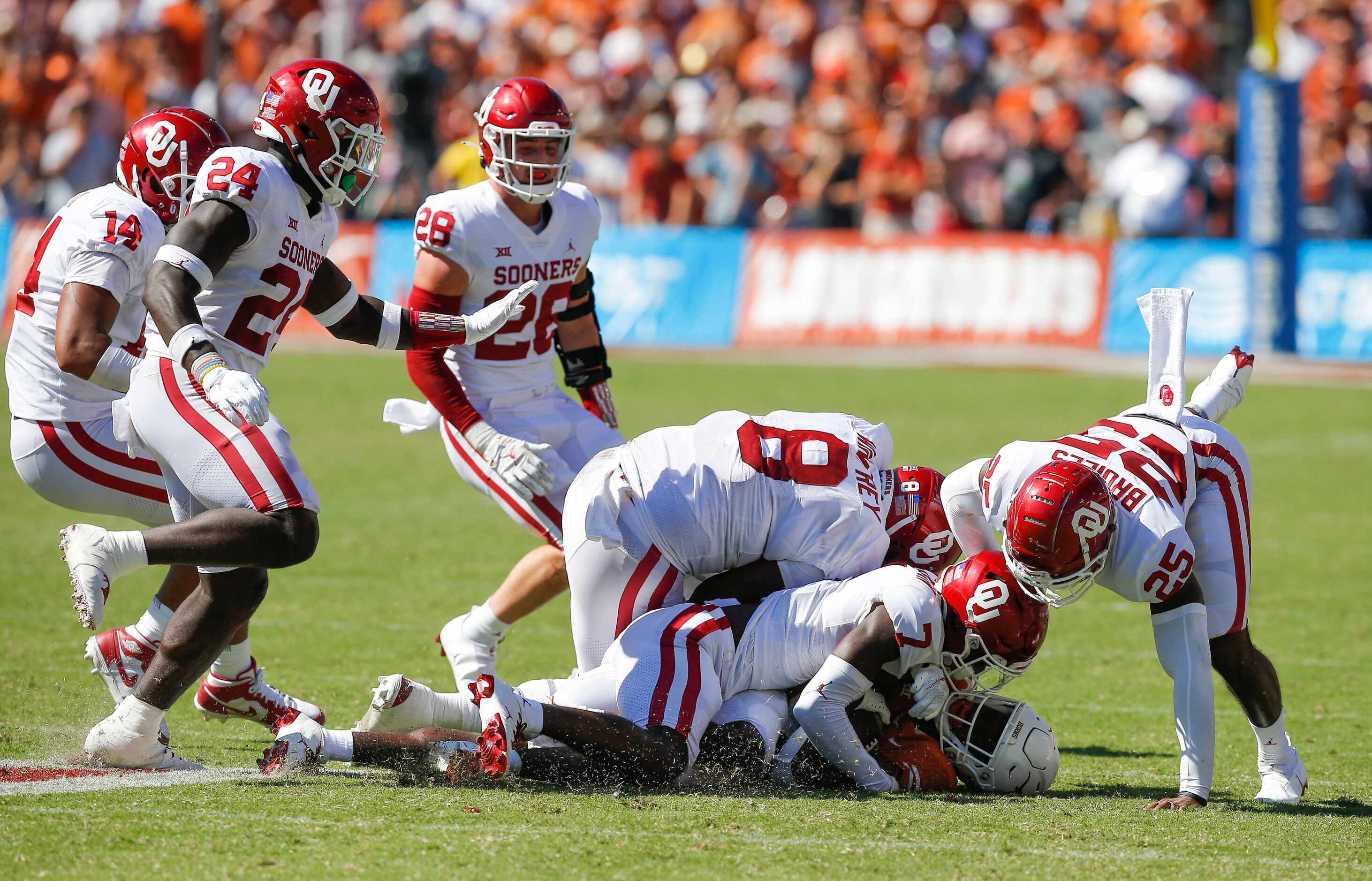 Texas wide receiver Casey Cain (88) is tackled by several Oklahoma defenders during the...
