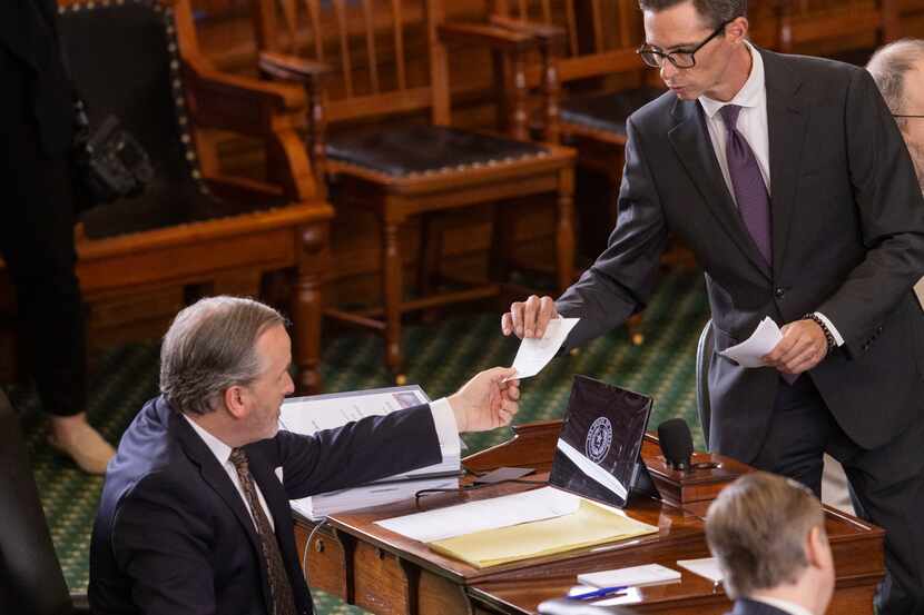 Texas Sen. Bryan Hughes, R-Mineola, hands his ballot in as senators vote on articles of...
