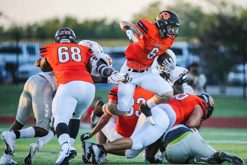 Rockwall running back Zach Henry makes a leap with the ball during a matchup between the...