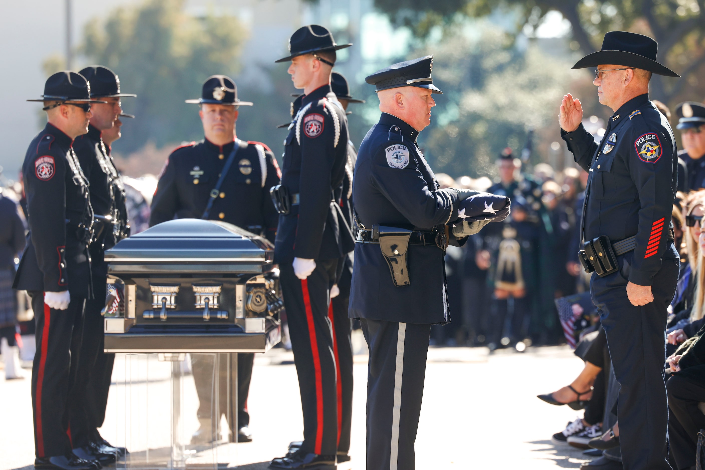 A folded flag is given to Greenville Police Chief Christopher Smith (right) during the...