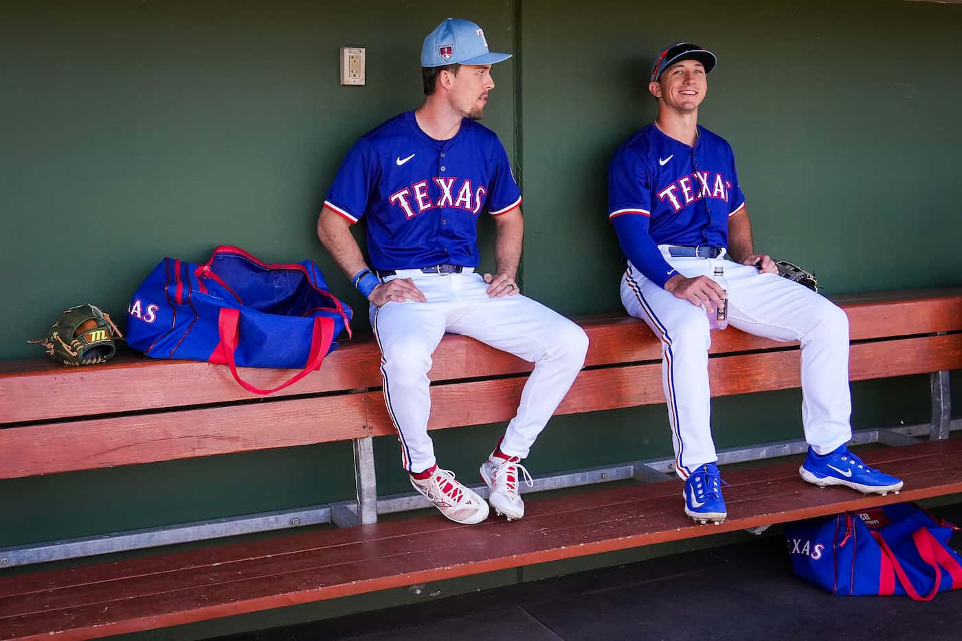 Texas Rangers outfielders Evan Carter and Wyatt Langford look out from the dugout before a...