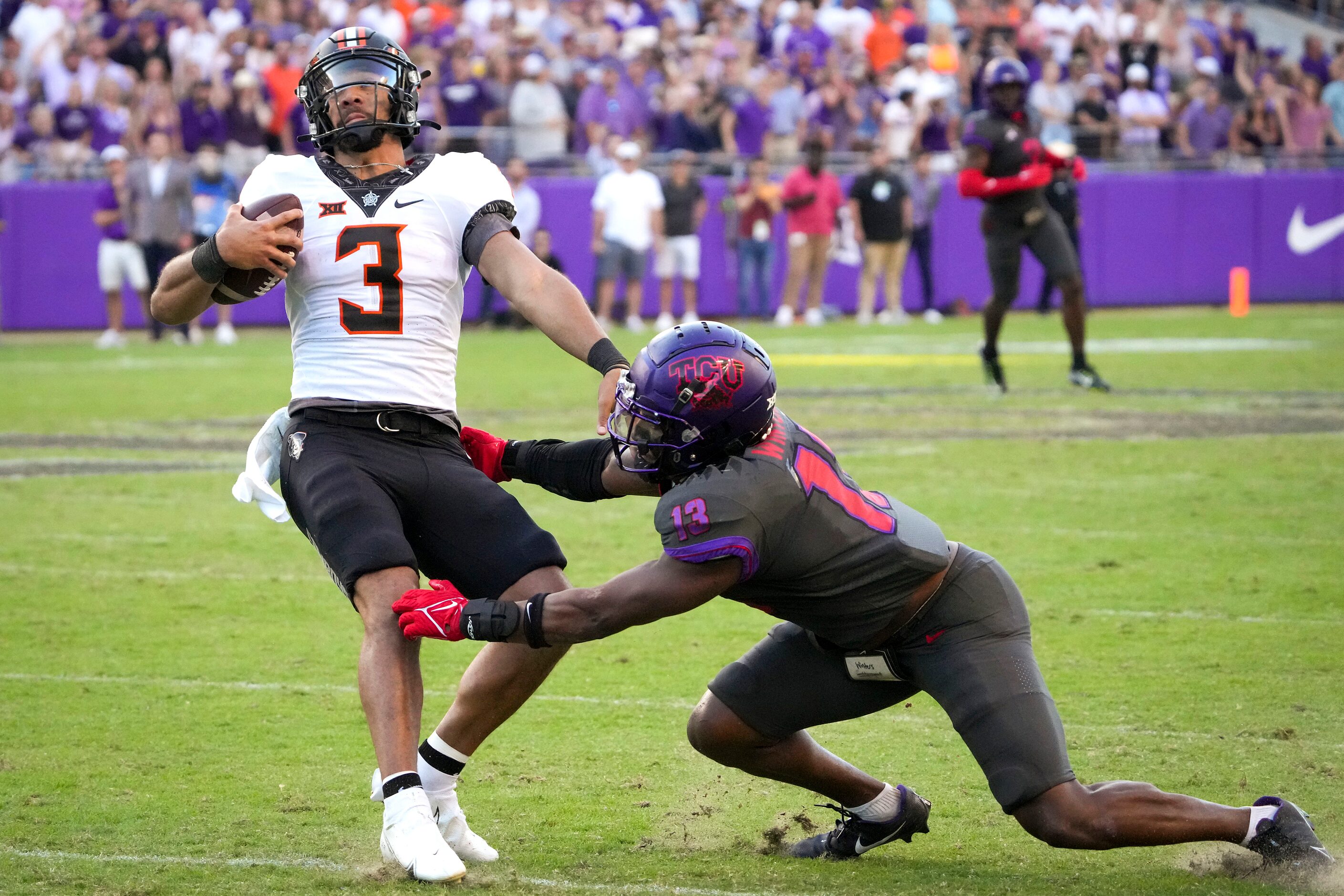 Oklahoma State quarterback Spencer Sanders (3) is brought down by TCU linebacker Dee Winters...