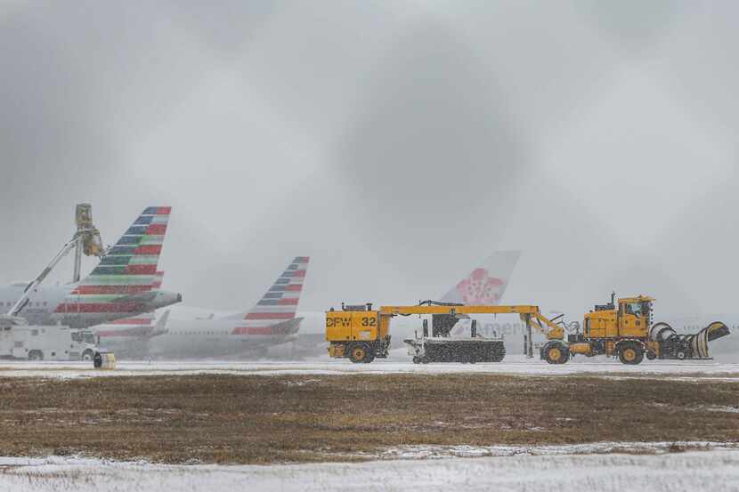 An American Airlines jets get inline to be de-iced at DFW International Airport before...