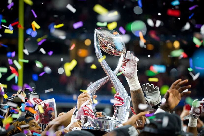 Alabama players reach for the game trophy as they celebrate after a 38-0 victory over...