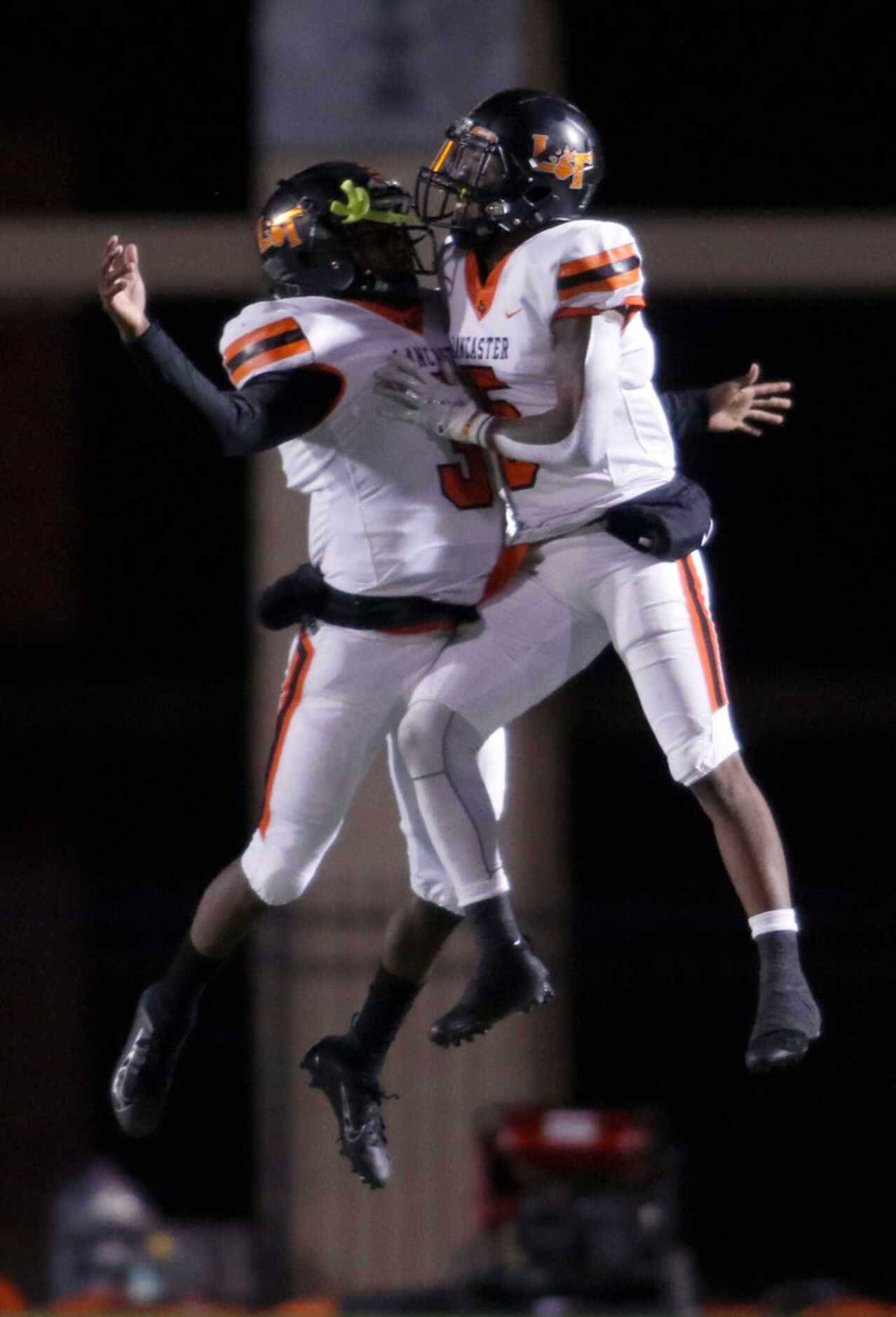 Lancaster quarterback Glenn Rice Jr. (3), left, leaps as he celebrates with teammate Malik...