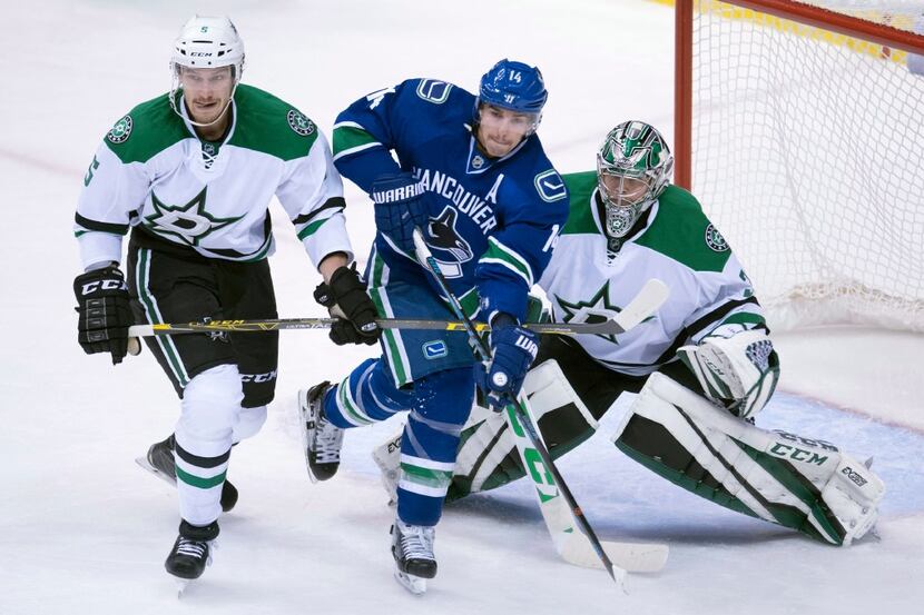 Dallas Stars defenceman Jamie Oleksiak (5) tries to clear Vancouver Canucks right wing...