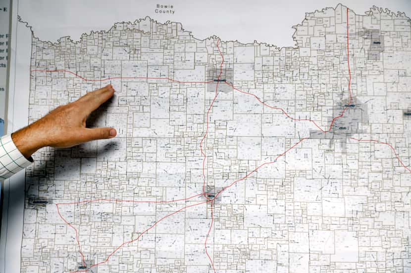 Cass County Judge Travis Ransom points where the small town of Marietta is on a map in...