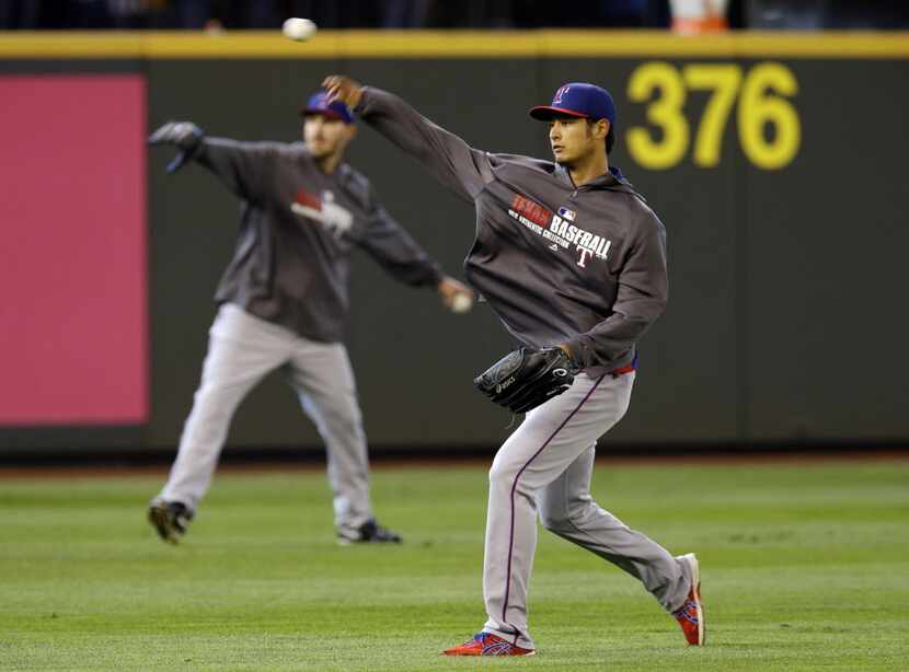 Texas Rangers pitcher Yu Darvish, right, throws in the outfield on Sunday, April 27, 2014,...