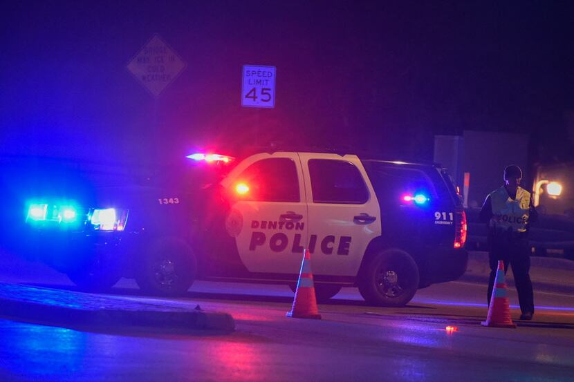 A Denton police officer blocks off a section of East University Drive near the intersection...