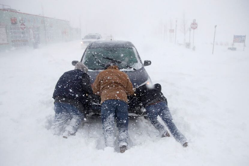 ASBURY PARK, NJ: A group of men help a motorist after his vehicle was stuck in the snow near...