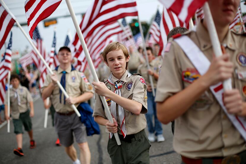 Koby Dunham, 13, carries an American Flag with Boy Scouts Troop 57 of Garland during the...